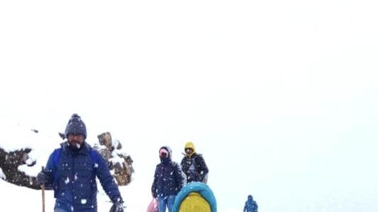 Tourists coming back during the snowfall in Triund.